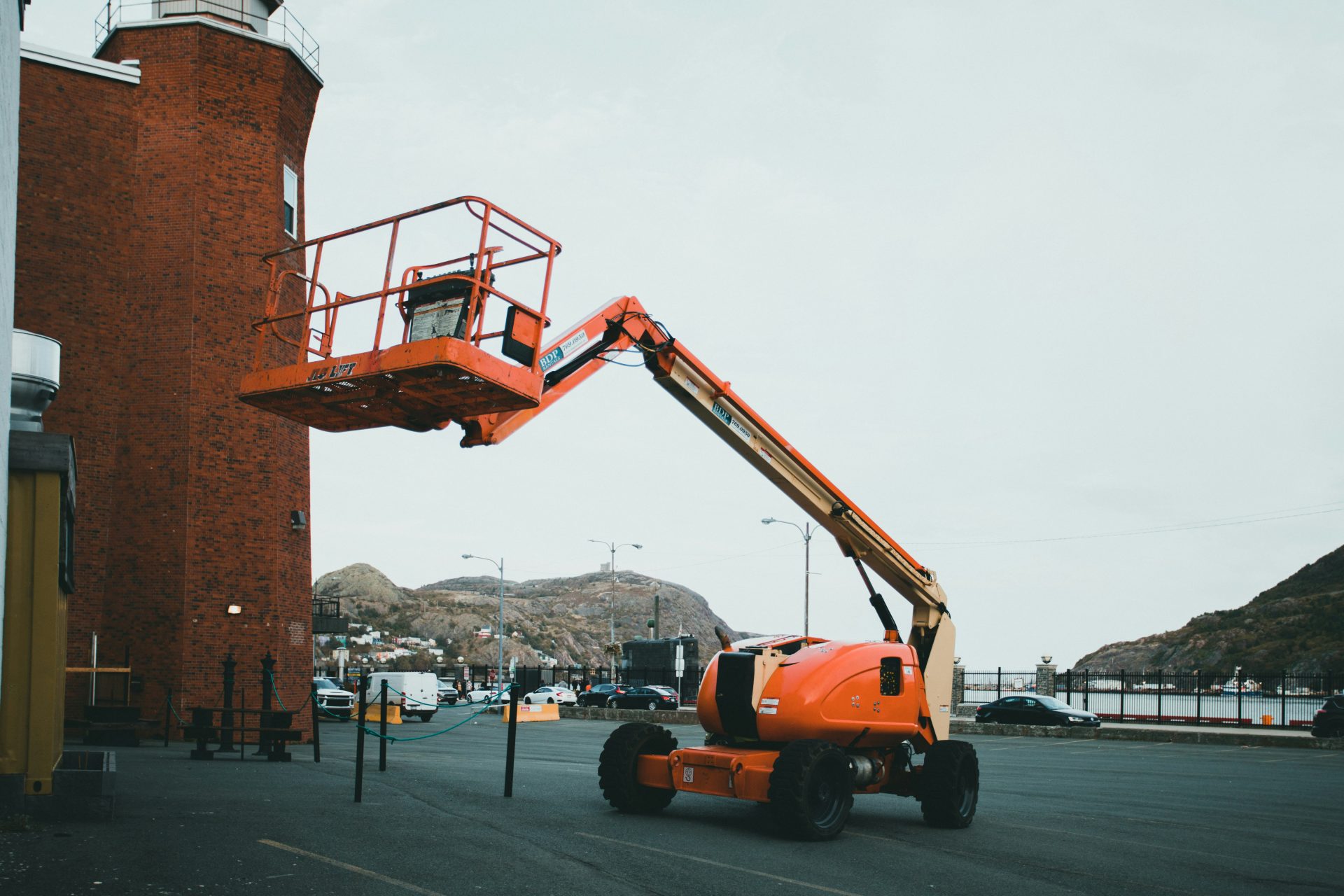 un gros camion orange garé à côté d'un grand bâtiment