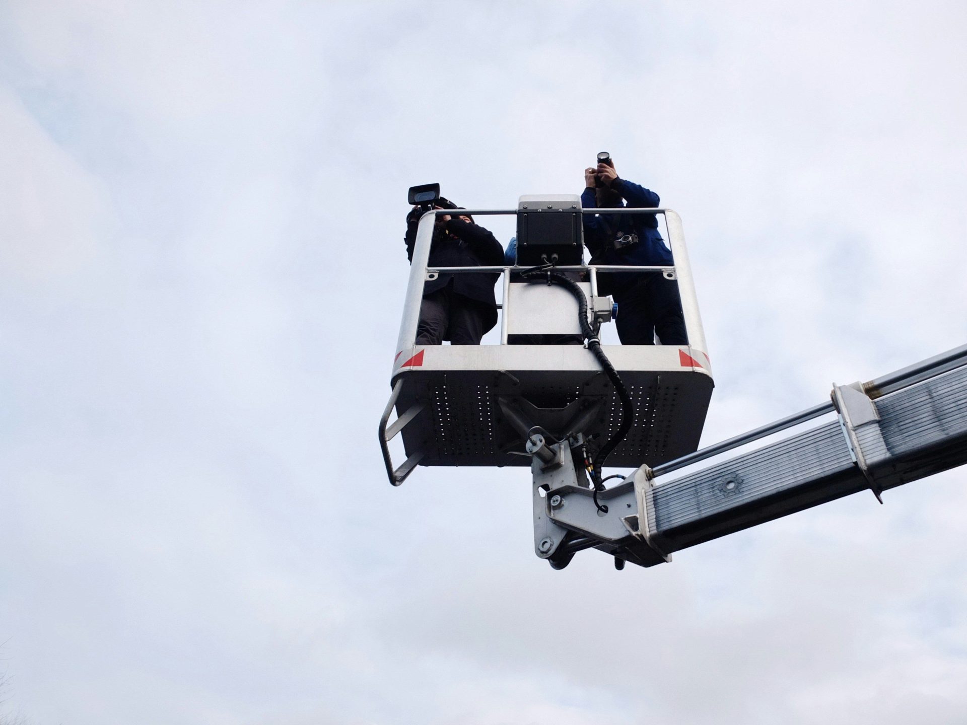 Deux personnes debout sur une remorque à nacelle élévatrice